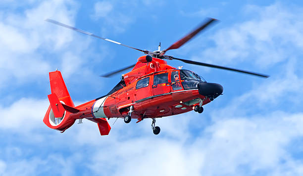 red rescue hubschrauber in blauer himmel bewegen - hubschrauber stock-fotos und bilder