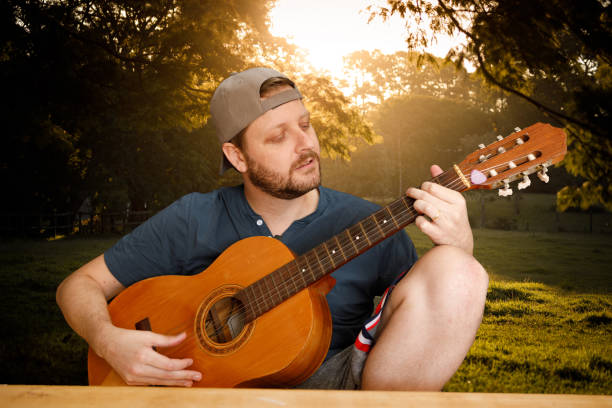 istock Man playing acoustic guitar on video conference call 1219282779