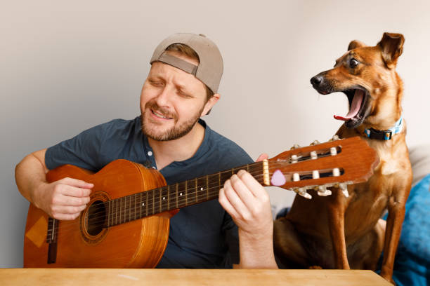 istock Man playing acoustic guitar on video conference call with funny background 1219282781