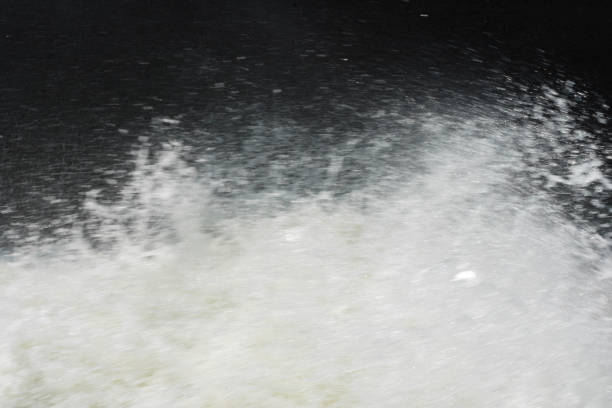 The water flows through the dam's floodgate. Severely cracking the rocky rapids and splashes into droplets
