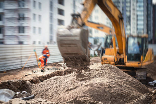 istock Yellow heavy excavator excavating sand and working during road works, unloading sand during construction of the new road 1219286895