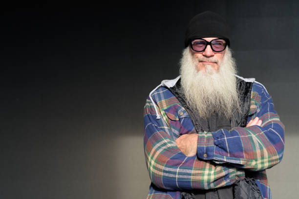 istock Mature bearded hipster man with sunglasses against black wall 1219288344
