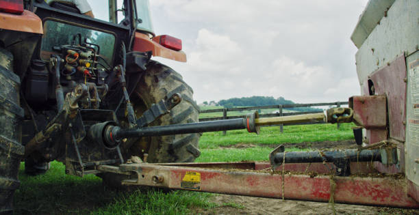 una tdf (eje de despegue de energía) alimenta una herramienta en la parte posterior de un tractor en una granja en un día parcialmente nublado - takeoff fotografías e imágenes de stock