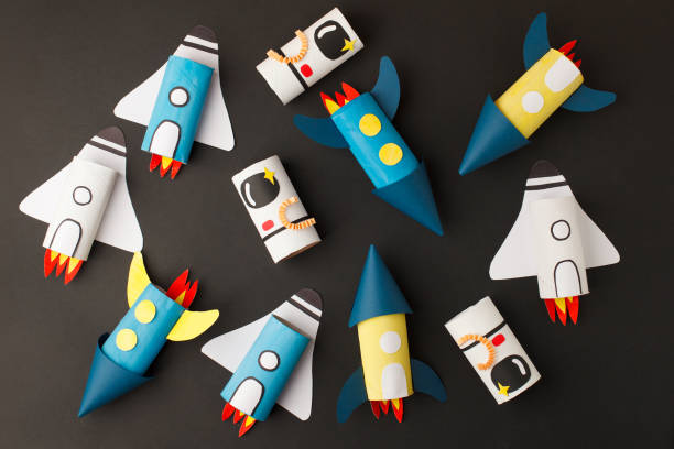 istock School kindergarten crafts, paper spaceship, shuttle, astronaut on black background with copy space for text. Party concept handcraft, diy, creative idea from toilet tube, recycle 1219291975