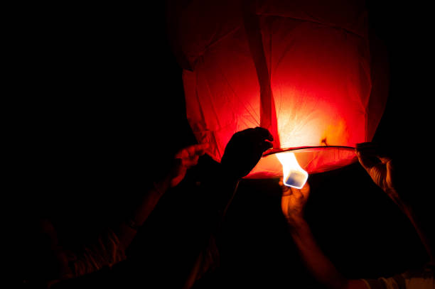 istock Person holding a red sky lantern with the flames showing clearly 1219297009