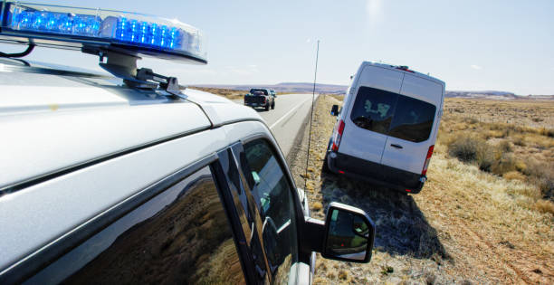 화창한 날에 유타 사막의 고속도로/고속도로 측면에 있는 대형 흰색 밴위로 불이 켜진 경찰 차량 - pulled over by police 뉴스 사진 이미지