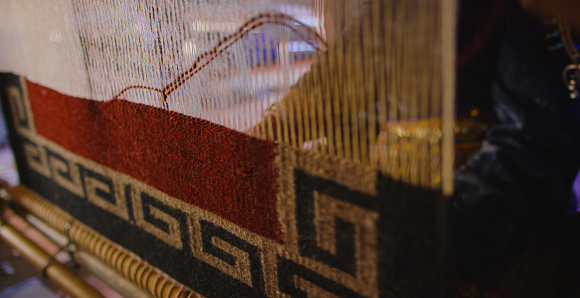 A Person Weaves a Navajo Blanket on a Loom