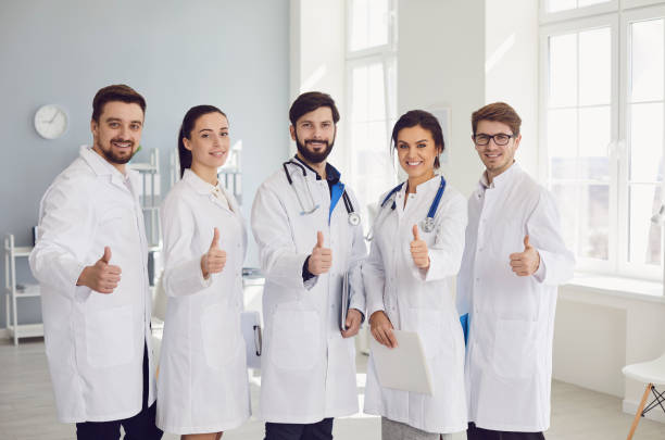istock Group of practicing doctors with stethoscope are smiling while standing in the clinic office. 1219303500