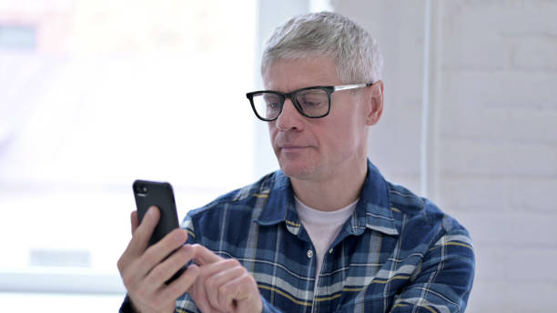 istock Portrait of Cheerful Casual Middle Aged Man Using Smartphone 1219304514