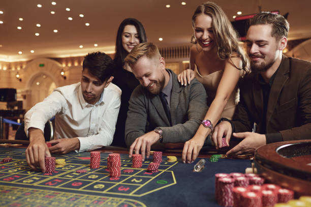 les amis heureux jouent à la roulette dans un casino. - roulette wheel photos photos et images de collection