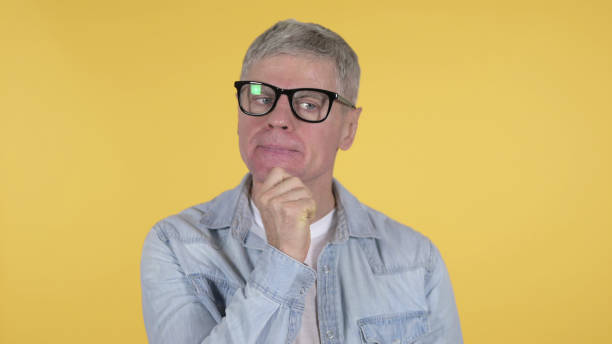 istock Thinking Casual Old Man Got New Idea on Yellow Background 1219307669
