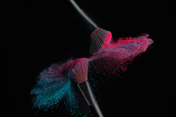 two brushes with pink and blue make up powder impact to make a cloud - face powder exploding make up dust imagens e fotografias de stock