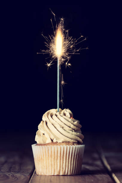 istock One cupcakes on a table with a sparkle and a black background 1219307930