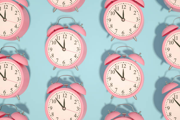 istock 3D Pink Alarm Clock on Blue Background 1219309086