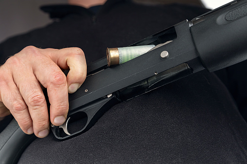 Hand discharges a gun .Shotgun in hand close-up.