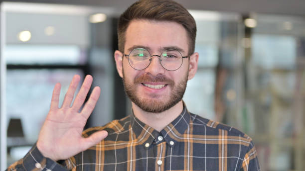 istock Portrait of Young Designer doing Video chat and Waving 1219310651