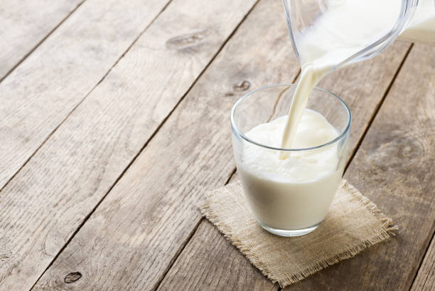 istock milk pouring into glass 1219310899