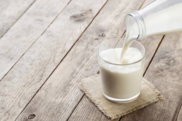 istock milk pouring into glass 1219310907