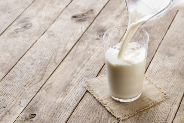 istock milk pouring into glass 1219310931