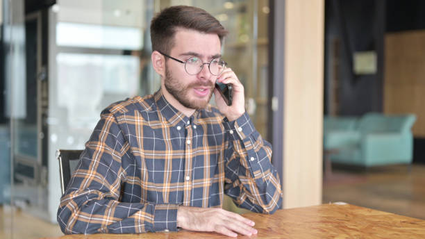 istock Attractive Young Designer talking on Smartphone in Office 1219311757