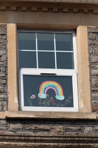 Bristol-April 2020-England-a close up view of a painted rainbow that has been stuck onto the inside of a window overlooking a main street-hope for the coronavirus-COVID 19 epedemic Bristol-April 2020-England-a close up view of a painted rainbow that has been stuck onto the inside of a window overlooking a main street-hope for the coronavirus-COVID 19 epedemic town of hope stock pictures, royalty-free photos & images