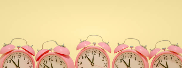 istock 3D Pink Alarm Clock on Yellow Background 1219315581