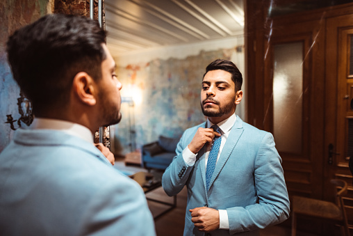 man dressing up in front of the mirror