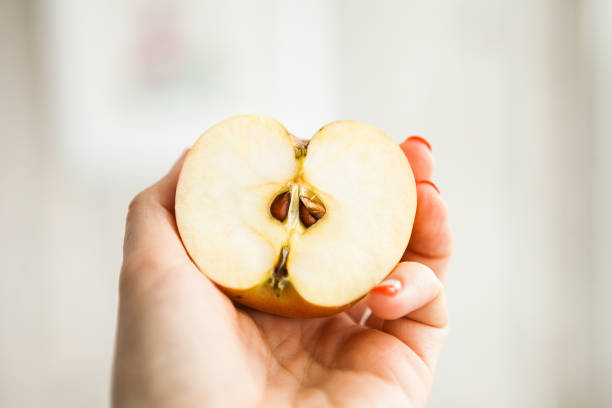 istock Half of the apple in somebody's hand 1219319442