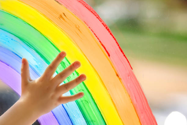 istock A child's hand on a painted rainbow. 1219320423