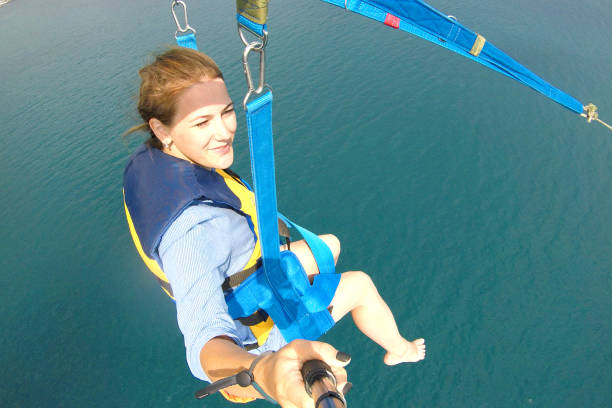girl is flying on a parachute above the sea