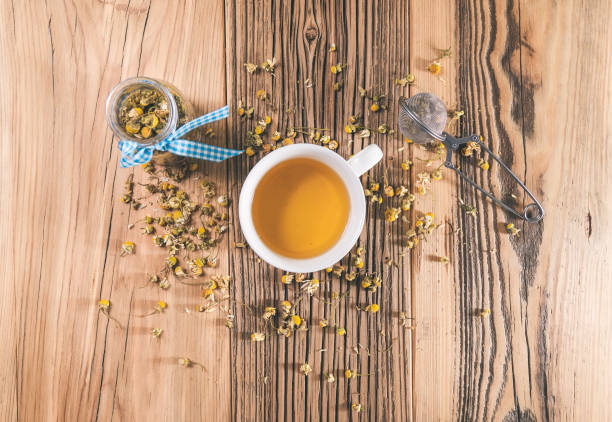 istock Chamomile tea with dried petals on wooden table 1219323670