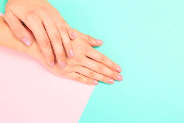 istock female  manicure. Beautiful young woman's hands on pastel   background 1219324111