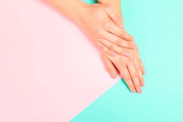 istock female  manicure. Beautiful young woman's hands on pastel   background 1219324112