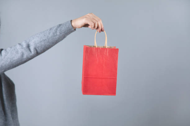 istock woman hand red shopping bag 1219326566