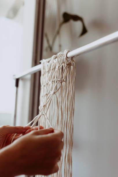 istock The girl weaves macrame. Boho decor in the process of weaving. Hand made 1219328882
