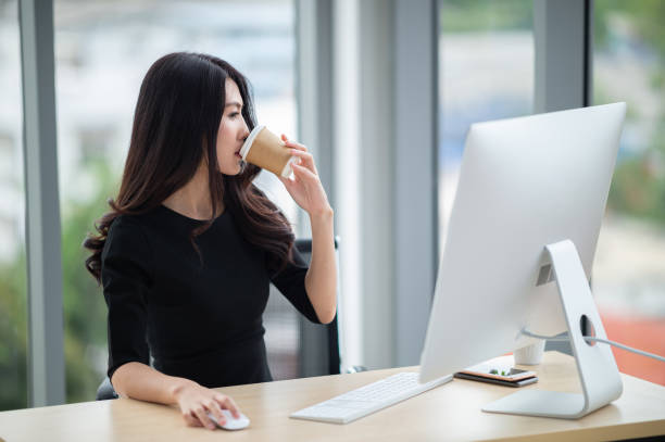 istock young business woman drink coffee while sitting at office desk 1219330351