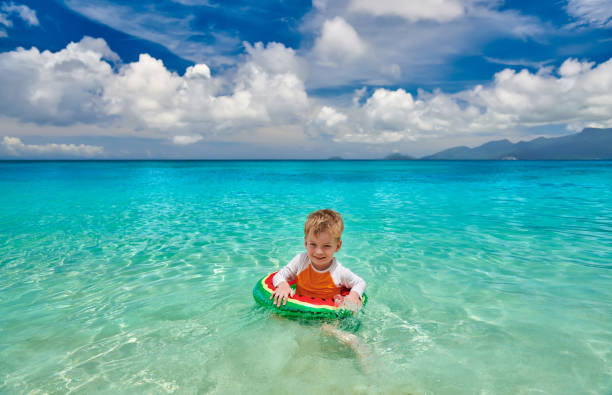 istock Toddler boy on beach swimming with inflatable ring 1219330714