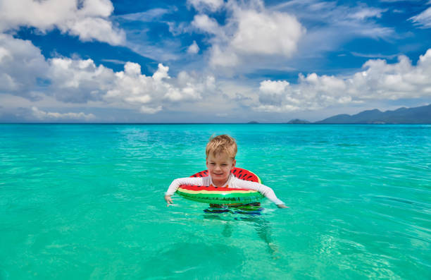 istock Toddler boy on beach swimming with inflatable ring 1219330718