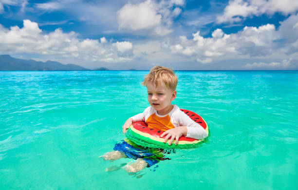 istock Toddler boy on beach swimming with inflatable ring 1219330720