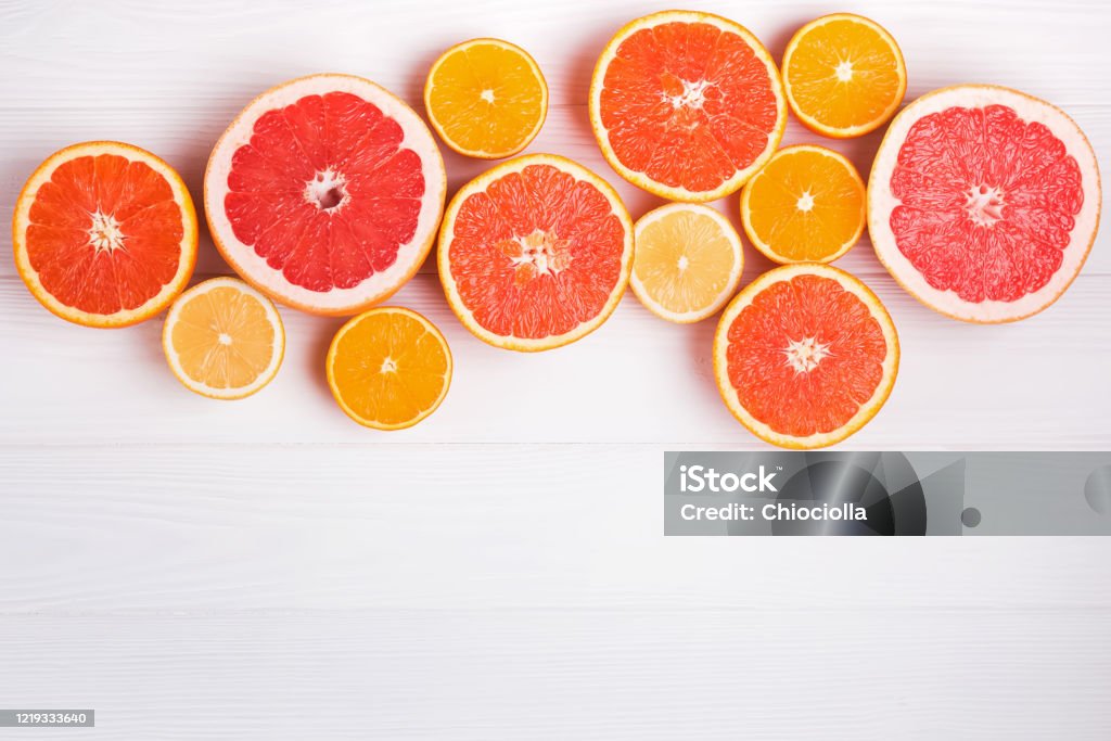 Flat lay composition with halves of different citrus fruits on white wooden background Flat lay composition with halves of different citrus fruits on white wooden background, top view Grapefruit Stock Photo