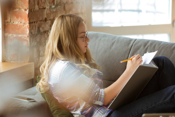 istock Young woman studying at home during online courses or free information by herself, making notes 1219334695