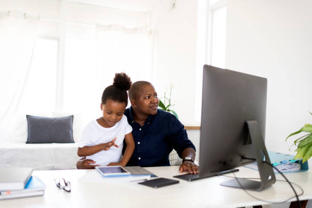 LGBTQ mother working at home with daughter sitting on lap LGBTQ mother working at home with daughter sitting on lap using digital tablet for homeschooling. female film editor stock pictures, royalty-free photos & images