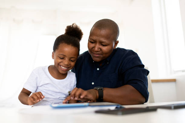 istock Mother using digital tablet with daughter homeschooling during lockdown 1219337034