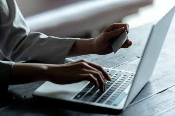 Young woman holding a credit card and working on a personal computer