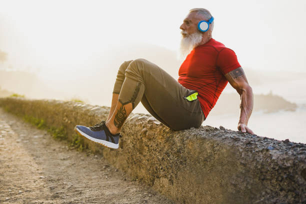 istock Senior fit man stretching outdoor at sunset before workout session - Mature athlete training outside while listening playlist music - Sport and joyful elderly lifestyle concept 1219338722