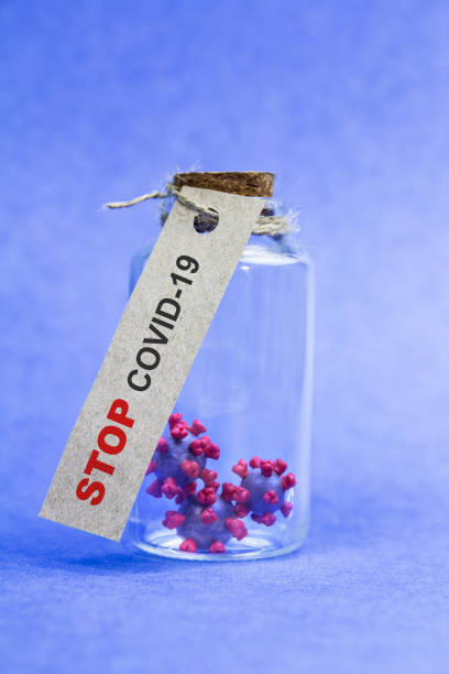 istock Stop covid-19 inscription on a flask with molecules on a blue background 1219342803