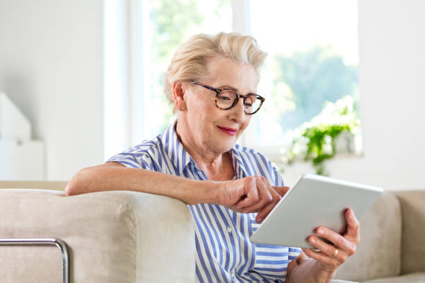 istock Elderly lady using digital tablet together at home 1219344351