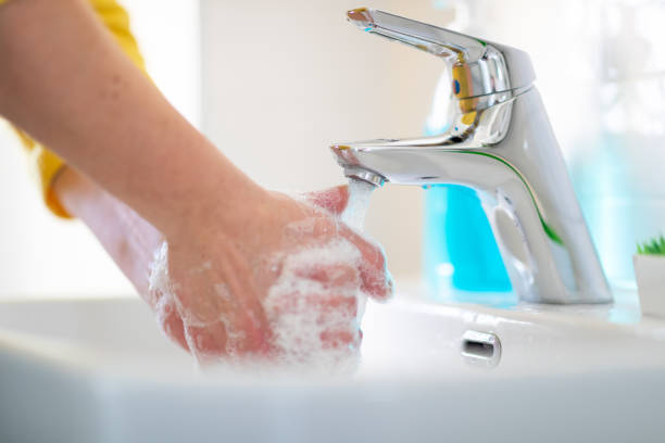 istock Washing hands and rinsing soap sud in bathroom sink 1219346316