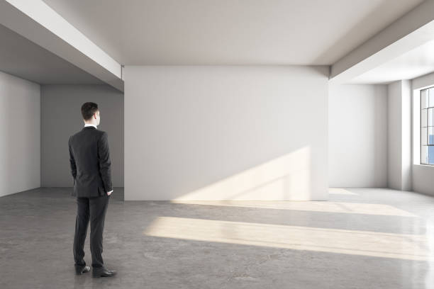 istock Businessman looking at blank wall 1219346612