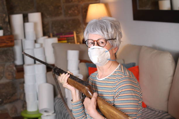 istock Senior woman holding weapon during quarantine 1219349034